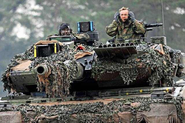 2023年2月1日，德国北莱茵-威斯特法伦州，德国国防部长皮斯托留斯（右）在豹2A6坦克上。图/视觉中国
