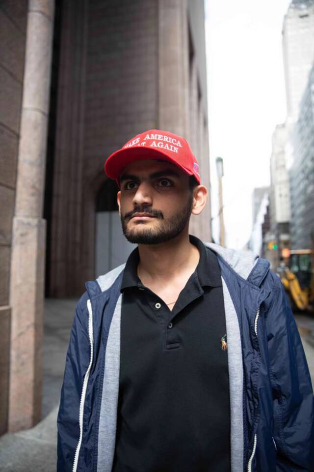 一名特朗普的支持者在曼哈顿特朗普大厦后面的麦迪逊大道上，戴着“让美国再次伟大”的帽子