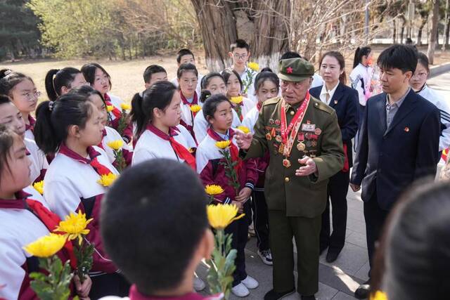 志愿军老兵李维波在沈阳抗美援朝烈士陵园内为学生们讲述战争经历。新华社记者潘昱龙摄