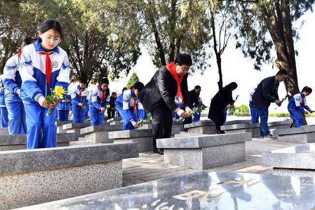 3月29日，在山东省菏泽市鲁西新区张和庄烈士陵园，张景宪（前排左二）和刘庙小学的师生为无名烈士献花。新华社记者郭绪雷摄