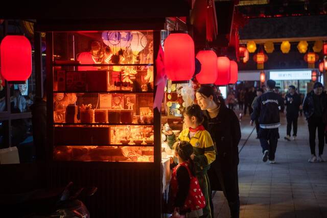 4月7日晚，游客在荆街市集选购文创产品。新华社记者伍志尊摄