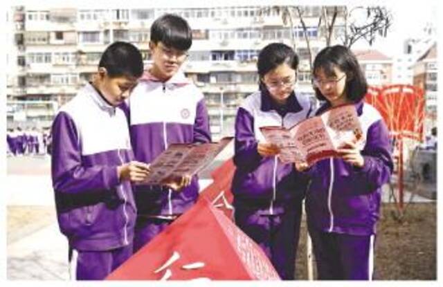 图为南开区田家炳中学学生近日在该校法治文化园学习民法典知识。