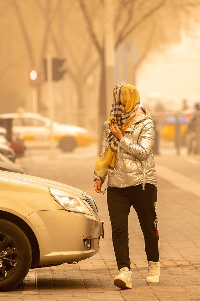 2023年4月10日，呼和浩特，市民围上纱巾在街头出行。视觉中国图