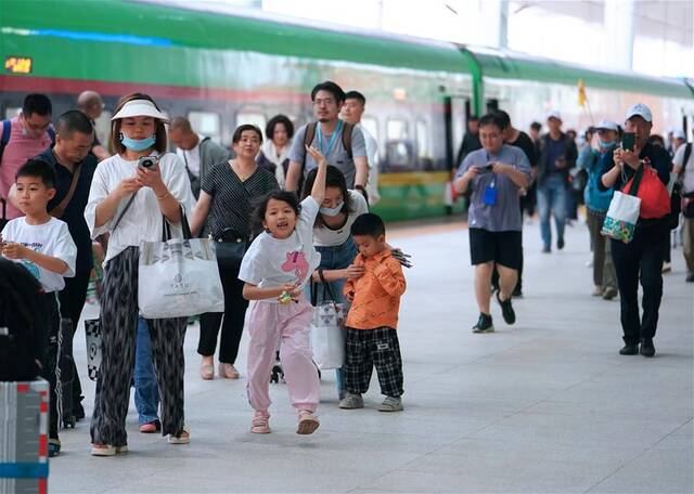 4月13日，乘坐D887次国际旅客列车的旅客抵达老挝万象站。新华社记者邢广利摄