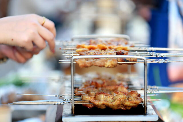 2023年3月31日，山东淄博一家烧烤店内，食客正在用小火炉烤肉串。中新社记者梁犇/IC图