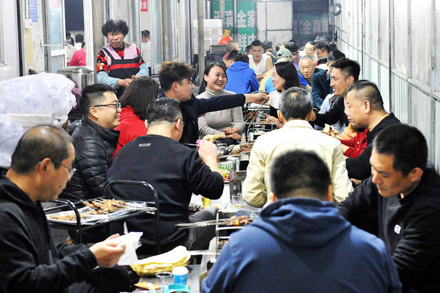2023年3月21日，山东淄博，三五好友坐着小马扎，围着小火炉吃烧烤，成为淄博最接地气的地摊饭局。视觉中国图
