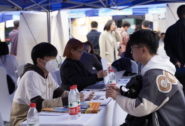 四川大学一场招聘会上，企业招聘人员在与学生交流（3月6日摄）。新华社记者邢拓摄