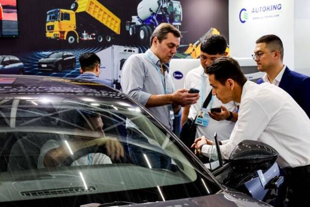  4月15日，采购商在广交会新设置的新能源及智能网联汽车展区了解中国新能源汽车产品。新华社记者刘大伟摄