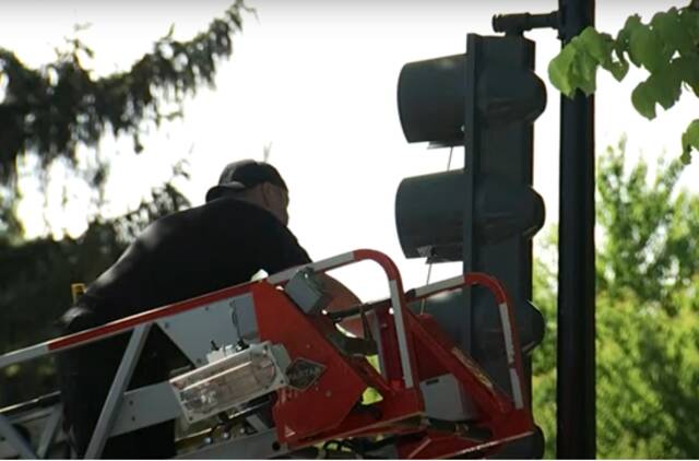 工作人员对被打爆红绿灯进行修理（美国俄亥俄州克利夫兰WKYC电视台视频截图）