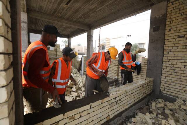 4月9日，在伊拉克巴格达省，伊拉克工人在一处示范学校项目施工现场工作。新华社发（哈利勒·达伍德摄）