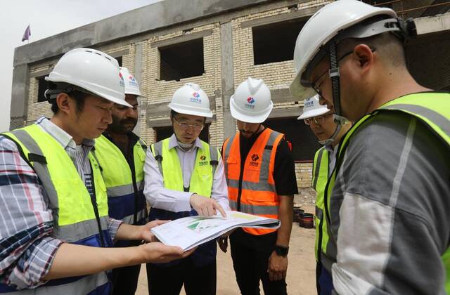 4月9日，在伊拉克巴格达省，中国和伊拉克工作人员在一处示范学校项目施工现场工作。新华社发（哈利勒·达伍德摄）