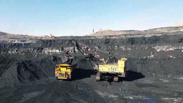 在山西一处露天煤矿，工作人员正在操作工程车辆装运煤炭。（新华社记者王飞航摄）