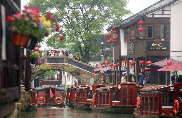 2023年4月29日，苏州，游客冒雨在山塘古街游览。