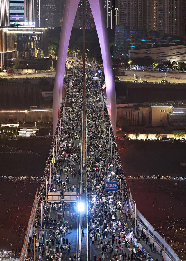 2023年4月29日，重庆洪崖洞封路封桥，千厮门大桥上挤满了密密麻麻的游客，方便游客打卡拍照。视觉中国图