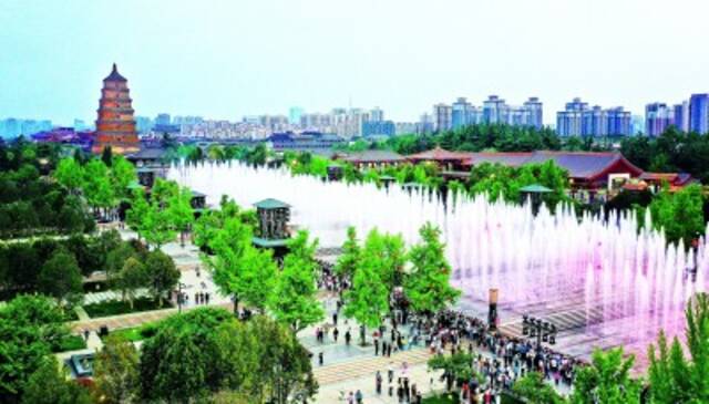 游人在陕西西安大雁塔北广场观看音乐喷泉表演。新华社发