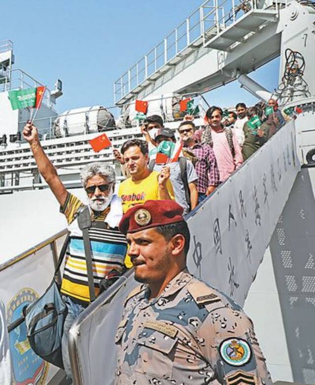 从苏丹撤离的外籍人员走下军舰舷梯。本报记者沈小晓摄