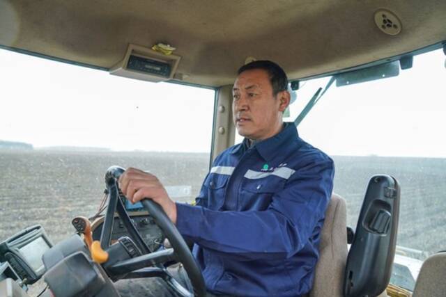 2023年4月12日，在黑龙江省北安市的北大荒集团建设农场有限公司一处农田中，许志国驾驶大型拖拉机进行分层定量施肥作业。新华社记者王松摄