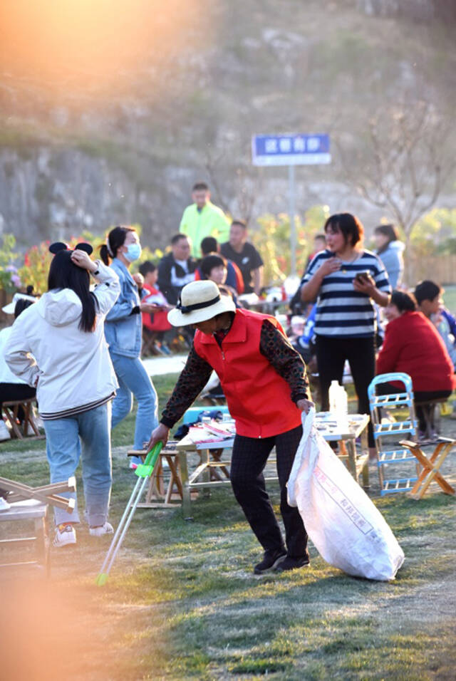 4月30日，在淄博市沂源县悦庄镇下龙巷村烧烤广场，一名志愿者在捡拾垃圾。