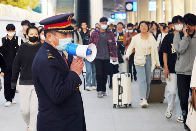 4月29日，淄博火车站工作人员在引导出站旅客。