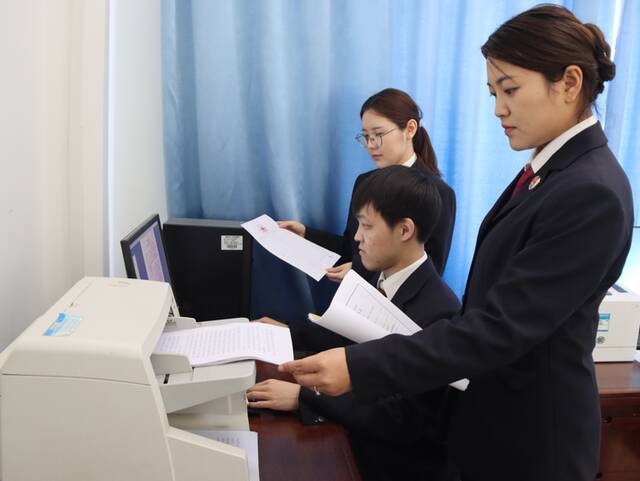图④:涞源县检察院案管部门工作人员正在扫描案卷制作电子卷宗。(马帅/摄)