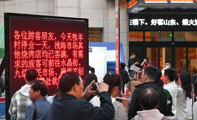 4月29日，在淄博一家烧烤店前，店主通过电子屏公示停业休息信息，提醒游客合理安排行程。（董乃德摄）