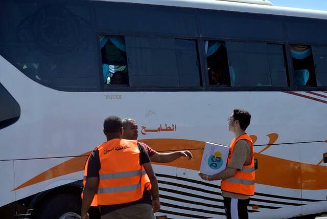 5月2日，在埃及南部阿斯旺省的一处汽车站，一名工作人员为逃离苏丹进入埃及的难民发放水。新华社发（拉德万摄）