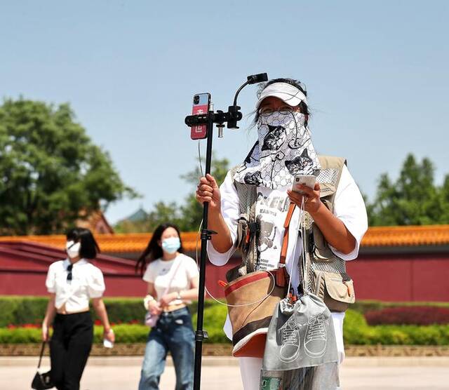 5月8日，北京持续晴空艳阳，紫外线照射强烈，在天安门广场的市民游客纷纷着清凉夏装出行，并采取各种措施遮阳防晒。