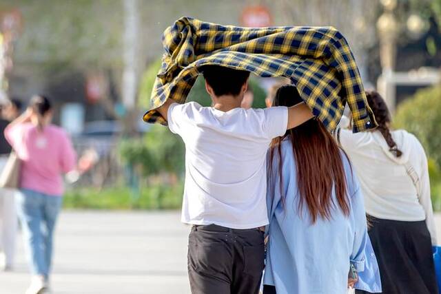 5月14日，郑州首遇初夏高温模式，户外气温直逼31℃，街头市民轻装出行，用各种方式防晒避暑。