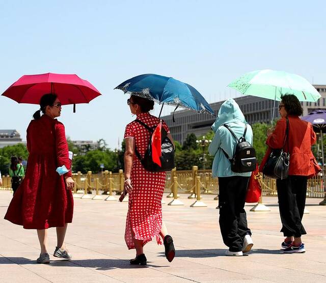 5月8日，北京，在天安门广场的市民游客采取各种措施遮阳防晒。