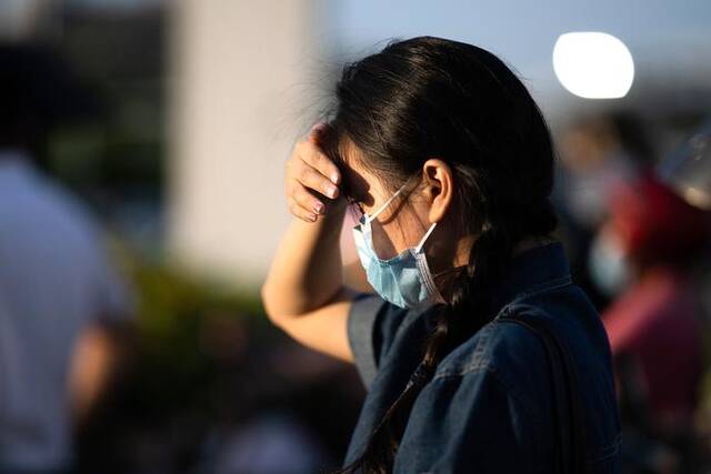 5月4日，广东东莞，天气炎热，出行的市民出门用手遮蔽刺眼的阳光。