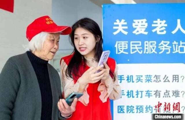 在江苏省海安市大公镇便民服务中心开设的老年人手机公益课堂上，志愿者指导老年人如何使用智能手机。翟慧勇摄