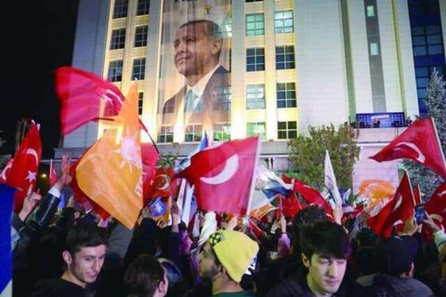 15日，土耳其安卡拉，总统埃尔多安的支持者在正义与发展党总部外挥舞旗帜。（法新社）