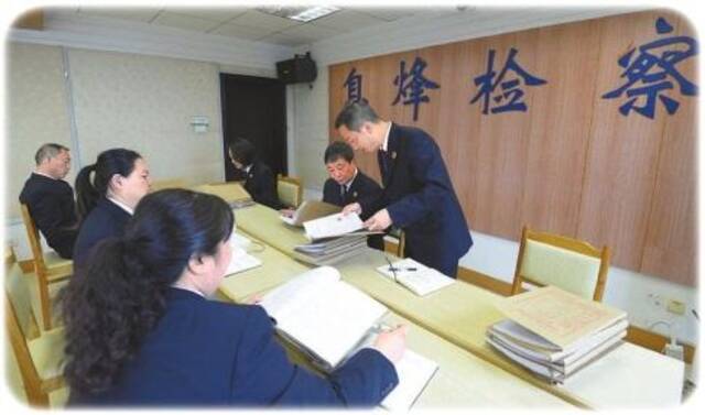 息烽县检察院检察官在评查中就发现的问题展开讨论。