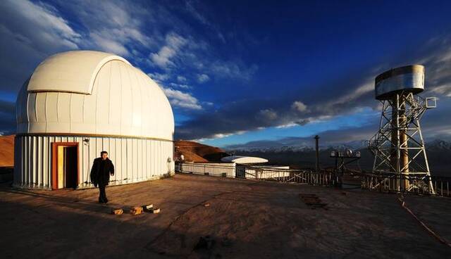 ↑5月24日，日落时分，在阿里天文台，尤显龙走出望远镜圆顶。