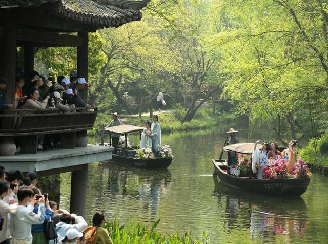 游客在杭州西溪湿地观看宋韵花朝节游船巡游（2023年4月2日摄）。新华社记者翁忻旸摄