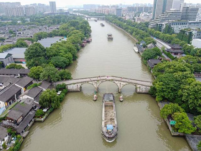 行驶在大运河上的货船通过杭州拱宸桥（2022年5月27日摄，无人机照片）。新华社记者江汉摄