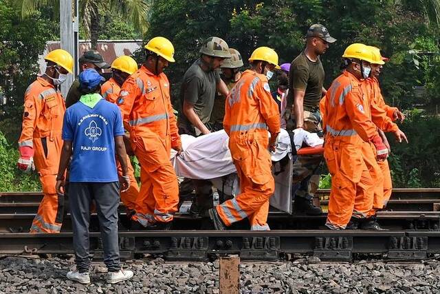 当地时间2023年6月3日，印度东部奥迪沙邦，三列火车相撞事故现场，救援人员抬着受害者的尸体。视觉中国图