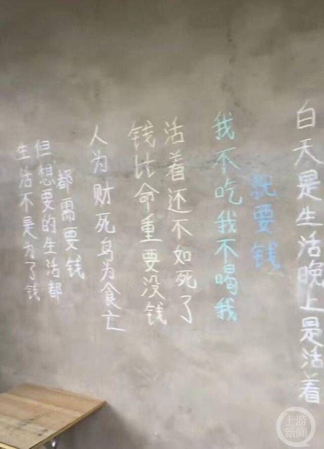 ▲墙上写满了“钱比命重要”等各种文字。