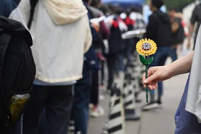2023年6月7日，上海，华东理工大学附属中学考点，一位家长拿着“向日葵”。澎湃新闻记者朱伟辉图