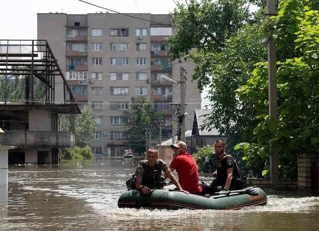  6月7日，赫尔松地区，乌克兰安全部队载着一名当地居民从洪水地区撤离。
