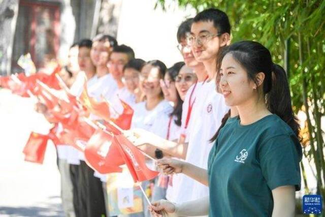 6月10日，大学生为火炬手加油。新华社记者任超摄