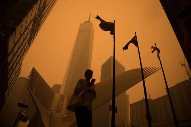 6月7日，一名行人从烟尘笼罩的美国纽约曼哈顿世贸中心附近走过