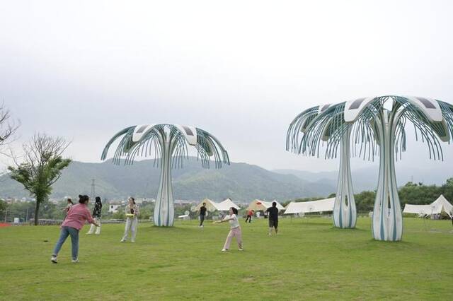 6月5日，在浙江省湖州市安吉县天荒坪镇余村乡村图书馆前，年轻人在草坪上玩飞盘。新华社记者才扬摄