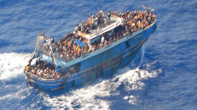 当地时间2023年6月14日希腊海岸警卫队发布照片，救援直升机俯瞰载满移民的海难船只。