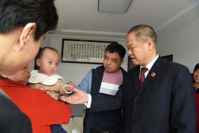 北京市房山区检察院干警到被害人家中回访,了解婴儿术后康复情况。