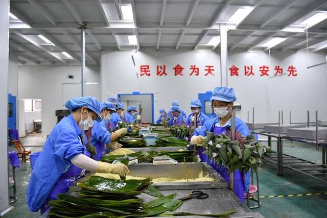 6月14日，工人在湖南蓝墨水农业发展有限公司制作粽子。新华社记者陈振海摄