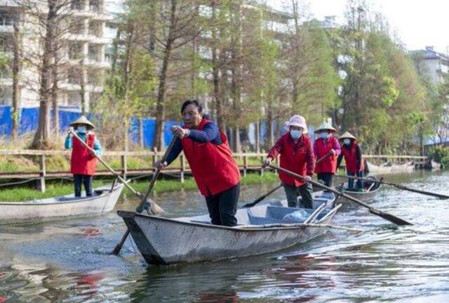 3月20日，李云丽（左二）带领巾帼打捞队队员划船准备到滇池草海开展打捞工作。新华社记者陈欣波摄