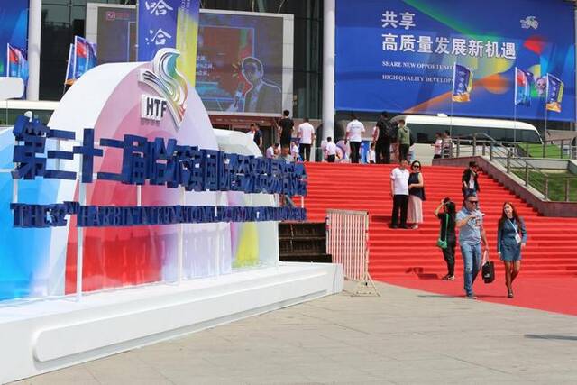 6月15日，与会者走在第三十二届哈尔滨国际经济贸易洽谈会现场。新华社记者石枫摄