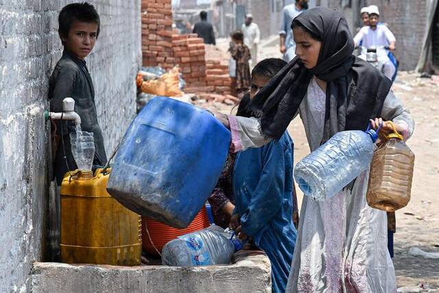 ▲6月18日，巴基斯坦拉合尔，孩子们用水龙头装满塑料水桶。