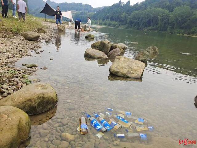 ↑游客放在河里的“冰镇啤酒”
